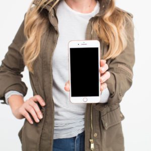 Image of woman holding an iphone up to show Instagram later scheduling app review