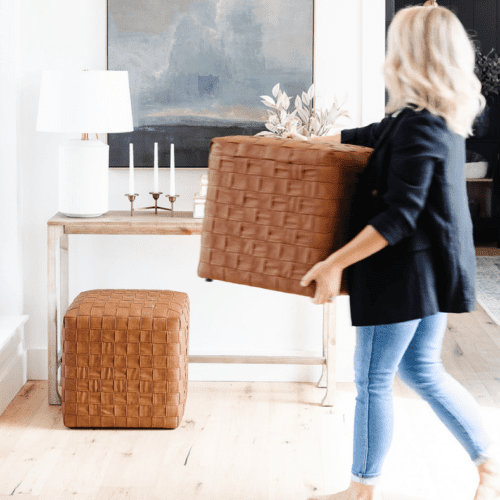 Woman moving storage containers around her house to help with how to start organizing.