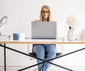 Woman working on computer showing Pinterest SEO work happening on Pinterest Desktop for Pinterest Idea Pins.