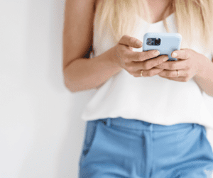 Woman holding phone - showing she's using her phone for Pinterest Idea Pins on the mobile Pinterest App.