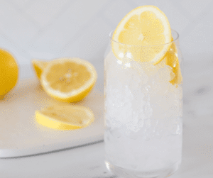 Glass of lemon water showing hydration to help get over sickness.