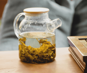Image of a glass tea kettle with tea brewing inside of it.