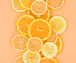 Image of sliced oranges laid out on orange cloth. 
