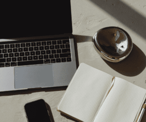 Image of a notepad beside a laptop showing items needed for how to plan your week to be productive! 