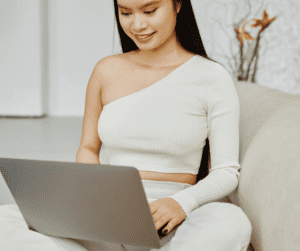 Image of a woman sitting typing on a laptop. 