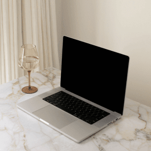 Image of an open laptop with wine glass beside with water for being productive working from home. 