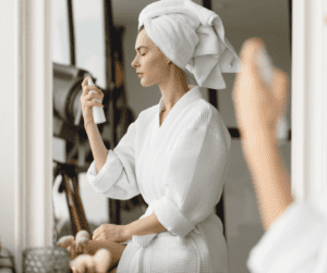 A woman spraying facial mist on her skin as part of taking care of her skin after getting a facial. 