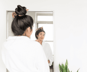 Woman using a roller on her face as part of skin care routine. 