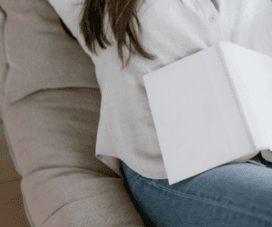 Image of woman with a white book laying on her. 