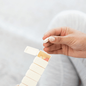 Image of person taking a pill out of pill box. 