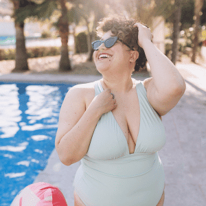 Image of woman by the pool enjoying summer supporting her humidity and migraines. 