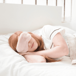 Image of woman laying in mask with eye mask for tips to get to sleep.