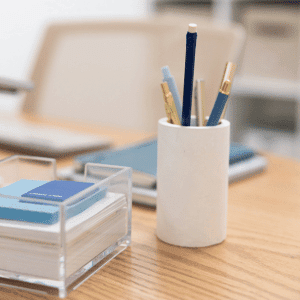 Image of post it notes and pens on a desk.