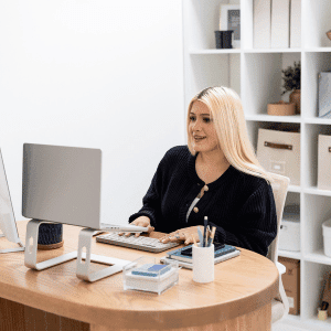 Image of woman working on a laptop at a desk on do you need a blog for pinterest.