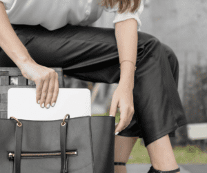Image of woman putting a laptop into a black bag as she's concluded her work on Best pinterest pin designs.