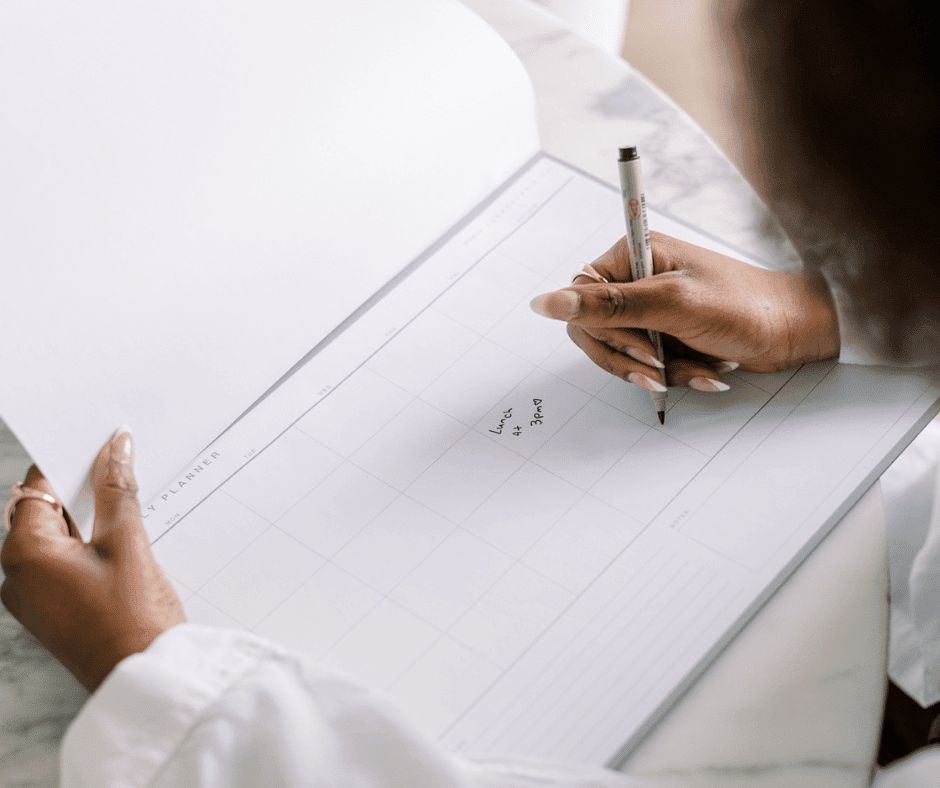 Image of woman making a monthly schedule on calendar notepad. 